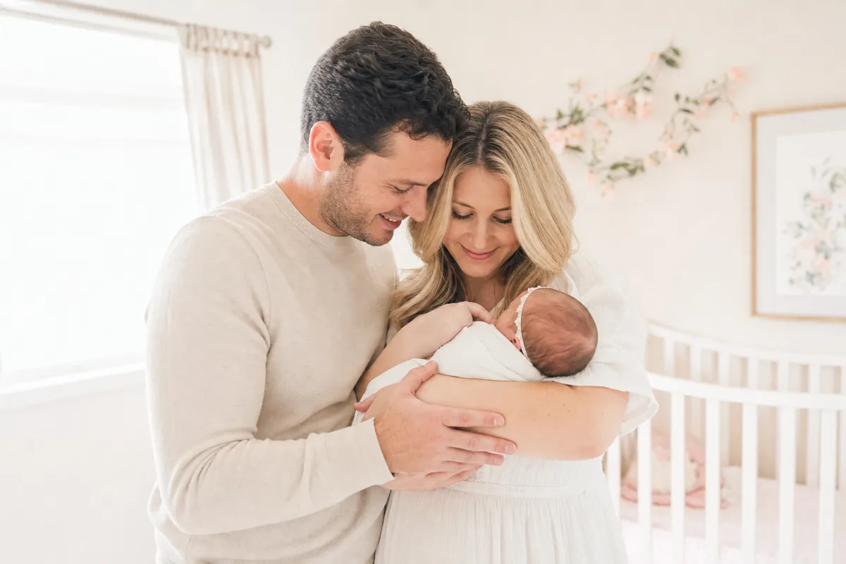New parents gently cradling their newborn in the nursery
